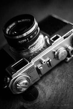 an old camera sitting on top of a wooden table