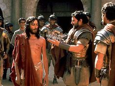 the actors are talking to each other in front of some men wearing roman garb