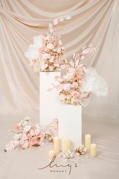 a tall white box with flowers and candles