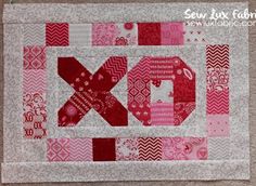 a quilted wall hanging with the word xo on it