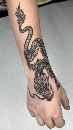 a hand with a dragon tattoo on it