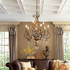 a living room filled with furniture and a chandelier hanging over the top of it