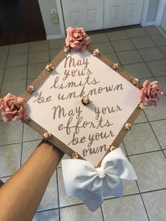 someone is holding up a graduation cap decorated with flowers and writing that says may your limits be unknown may your efforts be your own