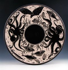 black and white plate with an octopus design on it's side, in front of a dark background