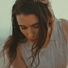 a woman with long hair looking down at her cell phone