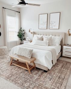 a bedroom with a bed, rug and two pictures hanging on the wall above it