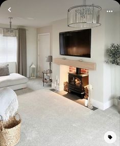 a living room filled with furniture and a flat screen tv mounted on the wall above a fire place