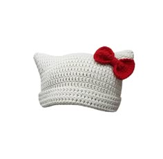 a white crocheted pillow with a red bow on the front and back of it