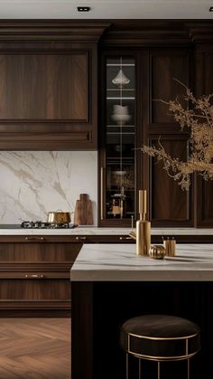 a kitchen with wooden cabinets and marble counter tops, gold accents on the stools