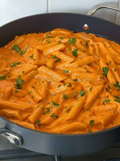 a pan filled with pasta and sauce on top of a stove