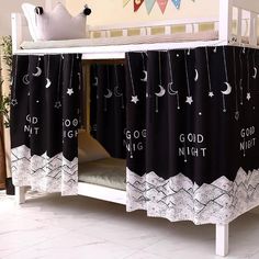 there is a black and white curtain on the side of a crib that says good night