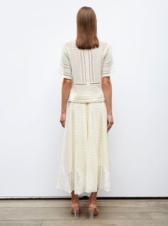 This light, flowing, gathered mid-length skirt is knit in Italy in a wicker-style stitch. It features a remarkable play of stitches and a flower design in jersey and moss-stitch knits that liven it up at the bottom. Its slightly flared cut is held in at the waist by a narrow scalloped knit waistband. In a "natural" color, it can be paired with Molli's entire summer palette from "kiwi" to "mimosa" yellow and can be paired with T-shirts and sneakers for an off-beat look or worn with flat "natural" Moss Stitch, Mid Length Skirts, Natural Leather, Leather Boots, Flower Designs, Yellow, Knitting, How To Wear, Color