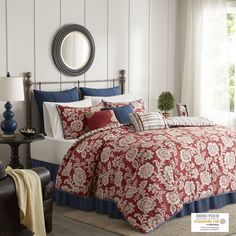 a bed with red and blue comforters in a room