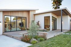 a modern house with large glass doors and wooden deck