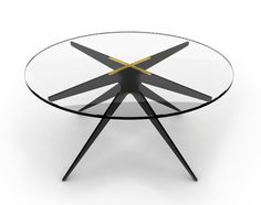 a glass table with black legs and a gold star design on the top, against a white background