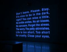 a dark room with blue text projected on the wall