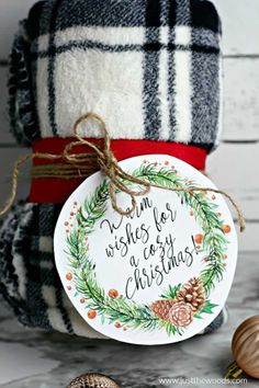 a christmas ornament sitting on top of a pile of blankets next to pine cones