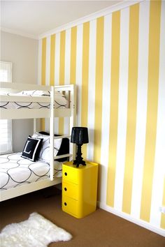 a bedroom with yellow and white striped walls