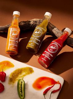 hot sauces and condiments sit on a cutting board