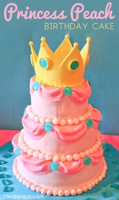 a pink and blue birthday cake with a gold crown on top that says princess peach