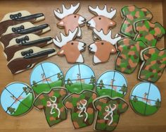 decorated cookies are arranged in the shape of deer heads and trees, on a wooden table