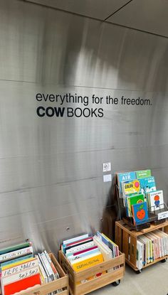 there are two wooden boxes with books on them and a sign that says everything for the freedom cow books