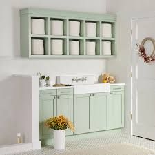 a bathroom with green cabinets and white walls