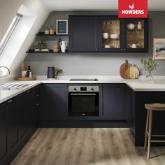 an image of a kitchen setting with dark cabinets and white counter tops on the walls