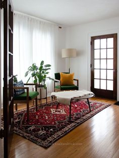 a living room filled with furniture and a rug on top of a hard wood floor