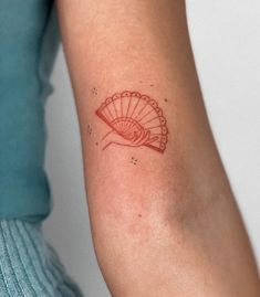 a woman's arm with a red tattoo design on the left side of her arm