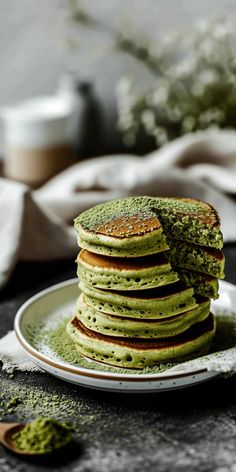 a stack of green pancakes sitting on top of a white plate