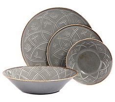 a gray and gold dinnerware set on a white background with an intricate design in the center