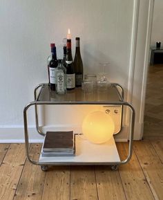 a table with some bottles on top of it next to a glass and bottle holder