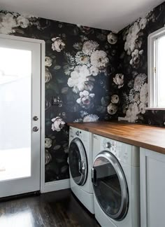 a washer and dryer in a room with floral wallpaper