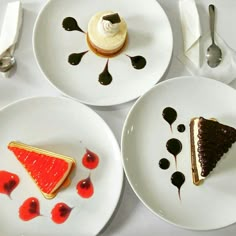 three white plates topped with desserts on top of a table next to utensils