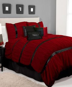 a bed with red and black comforters in a bedroom