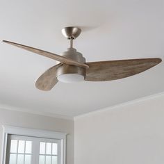 a ceiling fan in a room with white walls and wood trimmings on the ceiling