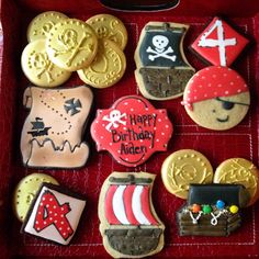 decorated cookies in a red box with pirate themed decorations on them and the words happy birthday ardenn