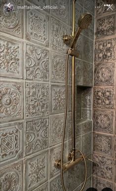 a shower head and hand held shower faucet in front of a tiled wall