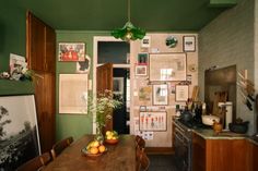 a kitchen with green walls and pictures on the wall