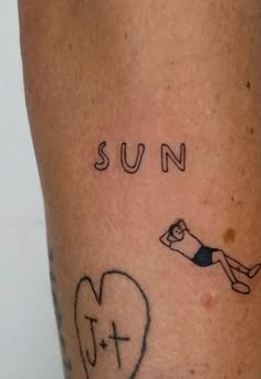 a person has a tattoo on their leg that says sun and a heart with a man diving into it