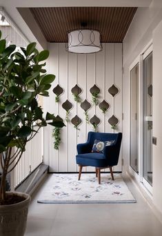 a blue chair sitting on top of a white floor next to a potted plant