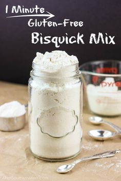 a mason jar filled with flour next to two spoons and a sign that says i minute gluten - free bisquick mix