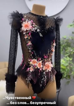 a mannequin with flowers and feathers on it's body in front of a wall