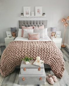 a bedroom with pink and gray bedding, white nightstands and pictures on the wall