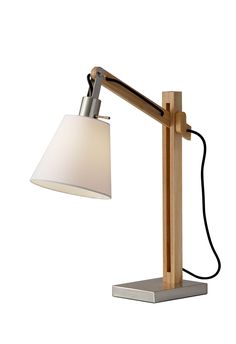 Introduce this Walden table lamp into rustic, contemporary or eclectic settings. Wooden joints adjust the balance arm to change the height and angle of the shade. The black fabric cord threads through the square wood post body and drapes out the back. The satin steel base and accents enhance an industrial style, while a clean off-white fabric shade softens the look. An on/off rotary switch is located on the socket. This lamp is smart outlet compatible. Bulb is not included. Adesso Walden Natural Rubber Wood Rotary Socket Table Lamp with Fabric Shade | 4088-12 Wooden Joints, Natural Lamps, Lamp Natural, Furniture Packages, Fabric Cord, Wood Post, Cfl Bulbs, Rustic Contemporary, Wood Shades