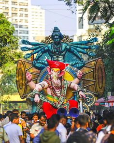 an elaborately decorated float in the middle of a crowded street with people walking around