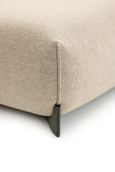 a close up view of the back end of a footstool with a beige cover