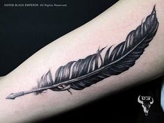 a black and white feather tattoo on the arm