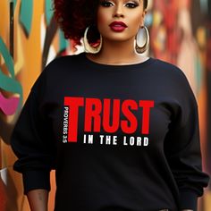 a woman with red hair wearing a black shirt that says trust in the lord